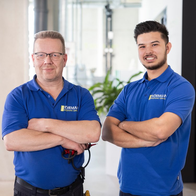 Zwei Männer in blauen Poloshirts