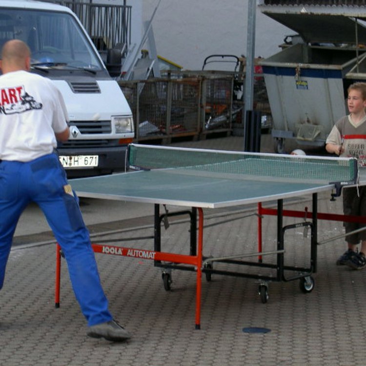 Ein Mann und ein Junge spielen Tischtennis auf dem Team Hörmann Sommerfest 2004