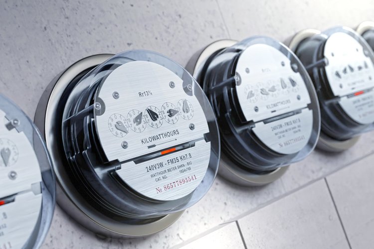 Smart Meter Mehrere analoge Stromzähler an einer Wand, mit einem scharf fokussierten Zähler im Vordergrund.