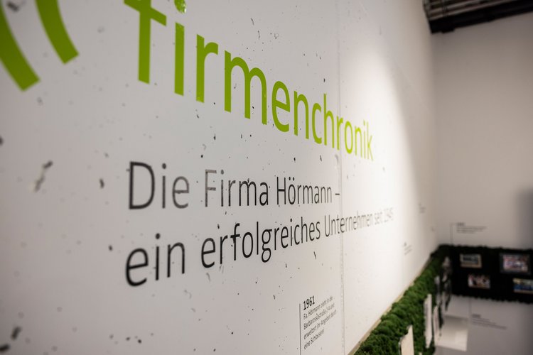 Eine Wand im Firmengebäude von Team Hörmann mit Auszügen der Firmenchronik
