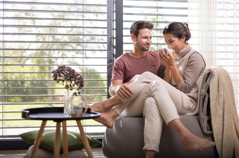Entspanntes Paar genießt Kaffee am Fenster