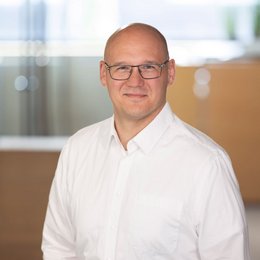 Marketing Mitarbeiter von Team Hörmann lächelt in die Kamera.