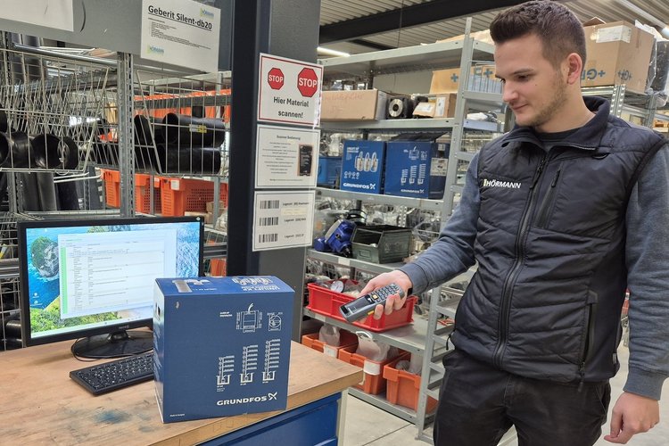 Digitales Lager bei Team Hörmann Ein Mitarbeiter von Team Hörmann scannt ein Paket im digitalen Lager mit einem Handscanner.