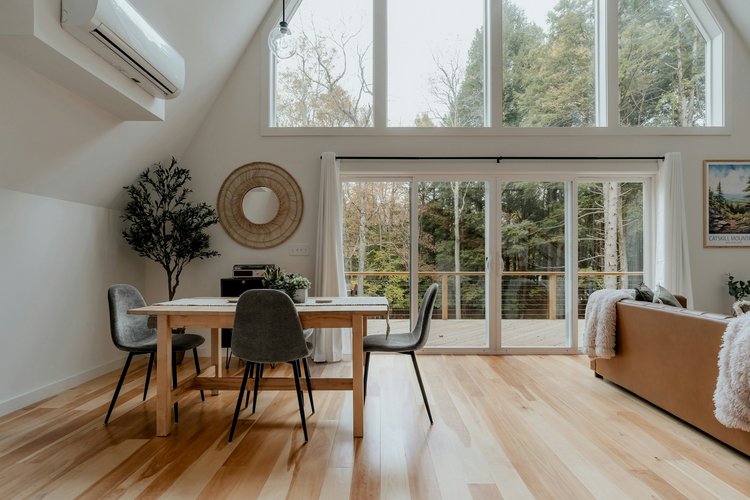 Wohnzimmer mit Holzboden Helles Wohnzimmer mit Fensterfront und Holzboden sowie Möbeln.