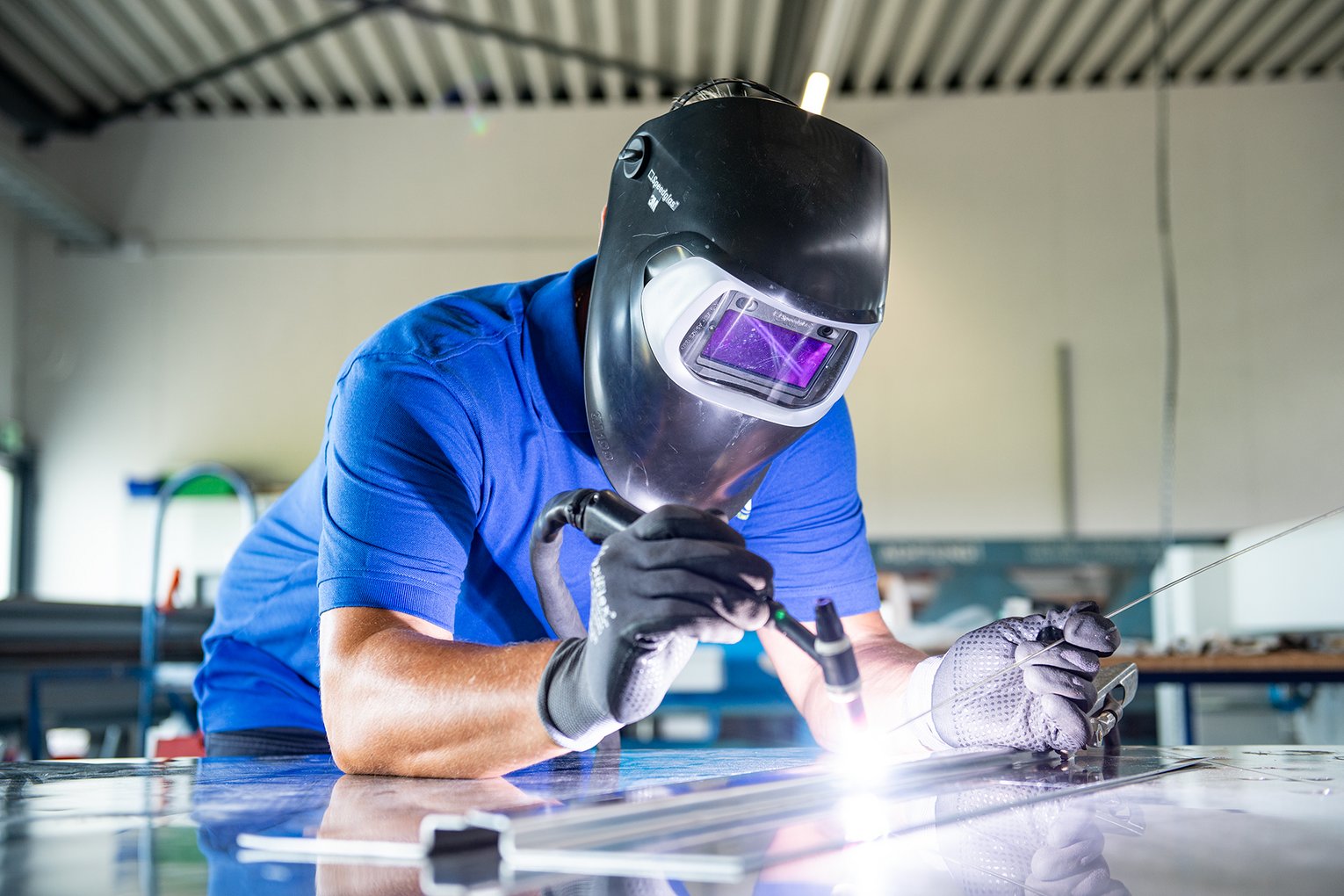 Ein Schweißer mit Schweißermaske bei der Arbeit