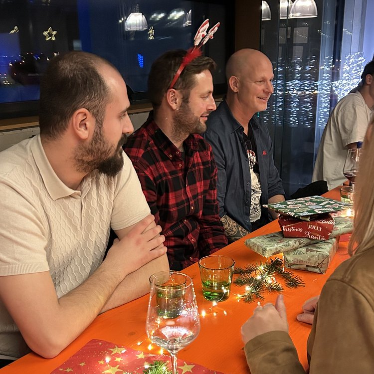 Mitarbeiter von Team Hörmann sitzen bei der Weihnachtsfeier gemeinsam an einem Tisch.
