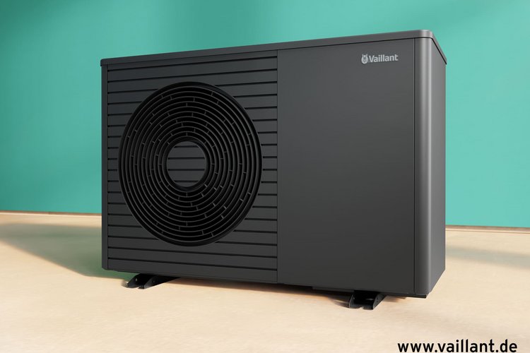 Schwarze Wärmepumpen-Außeneinheit von Vaillant vor türkisfarbener Wand auf hellem Boden, modern und kompakt gestaltet.